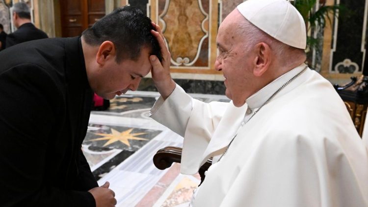 Il saluto di un sacerdote che riceve la benedizione del Papa