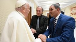 Pope Francis shakes hands with the two bereaved fathers
