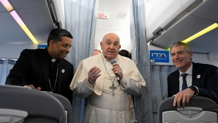 Papa Francesco mentre saluta i giornalisti sul volo verso Ajaccio