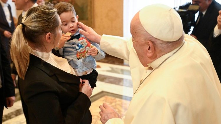 Francesco mentre si intrattiene con una mamma e il suo bambino