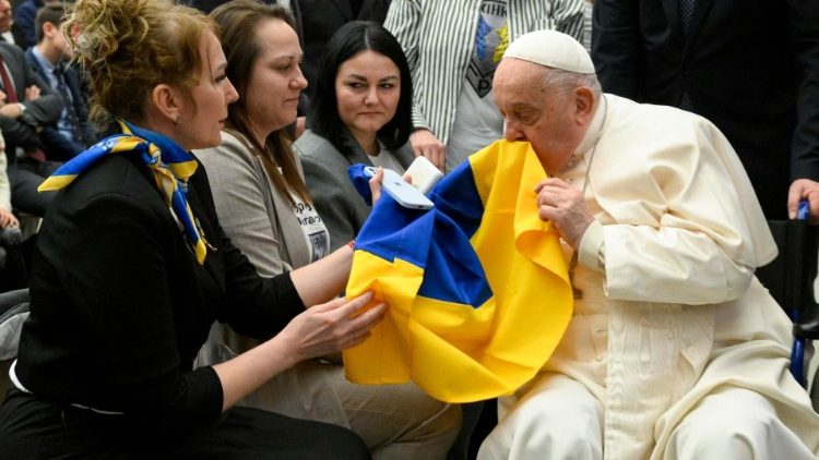 Der Papst küsst während der Audienz eine ukrainische Fahne