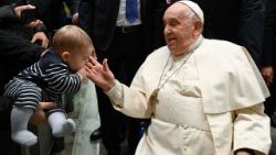 Ferenc pápa a szombati audiencián a hívek körében megsimogat egy kisbabát
