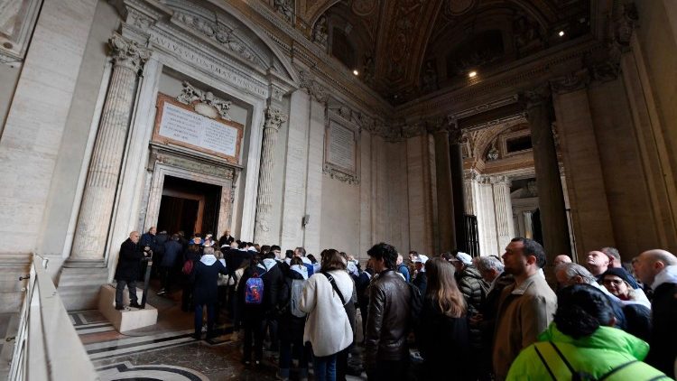 Peregrinos se preparan para cruzar la Puerta Santa de la Basílica vaticana.