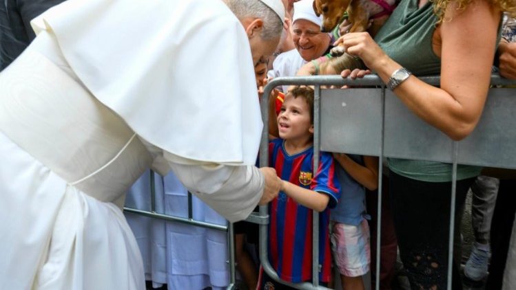 Pope Leo greets a child on his way to the Mass in Albano