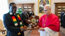 The Pope and President Mnangagwa hold a gift from the Zimbabwean President