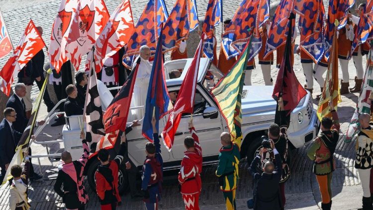 Papamobil v pestrobarevném obklíčení 