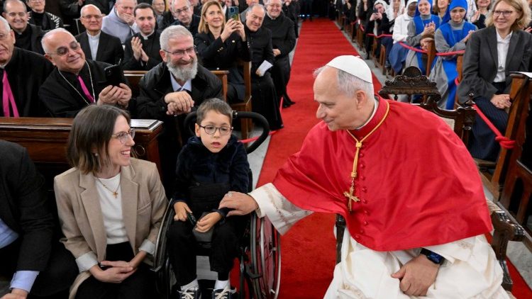 Leone XIV mentre parla a una famiglia prima della scatto della foto di gruppo