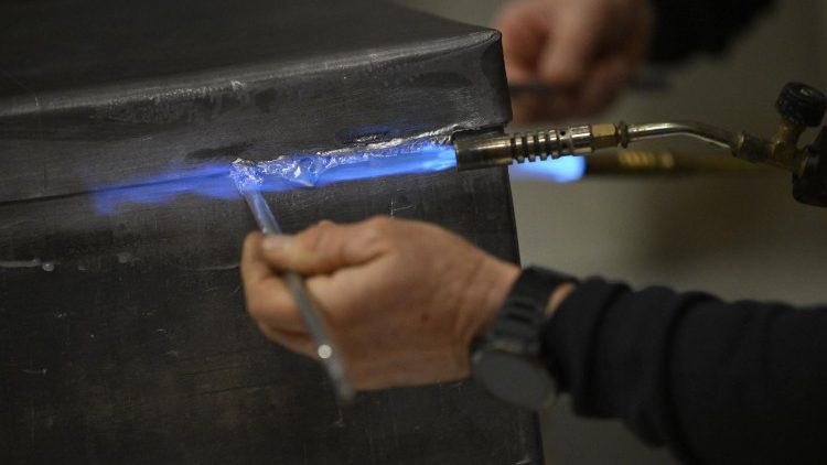 A sampietrini seals the lead box that contains the bronze capsa