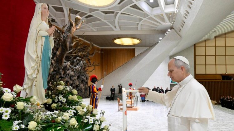 Papa Leone XIV accende un cero davanti alla statua della Beata Vergine di Lourdes, in Aula Paolo VI