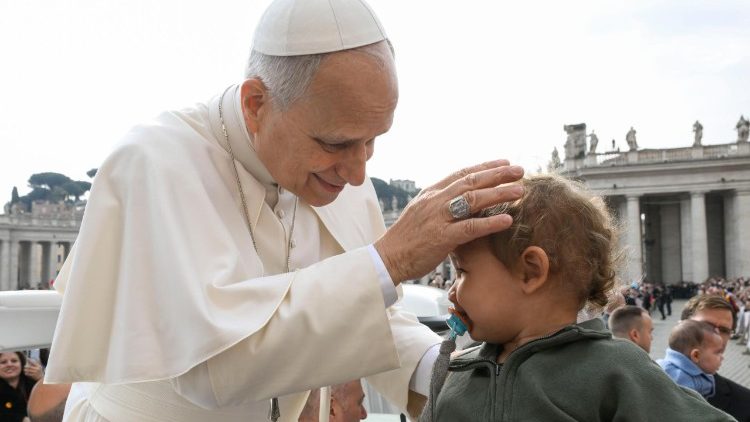 Leone XIV benedice un bambino durante il suo giro tra i fedeli in Piazza San Pietro