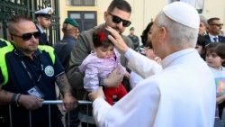 Papież Leon XIV błogosławi małą dziewczynkę podczas swojej wizyty duszpasterskiej w Acerra 23 maja 2026 r.  (@VATICAN MEDIA)