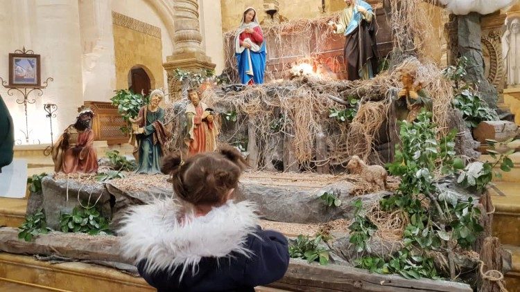 un bambino davanti al presepe in una Chiesa maronita di Aleppo