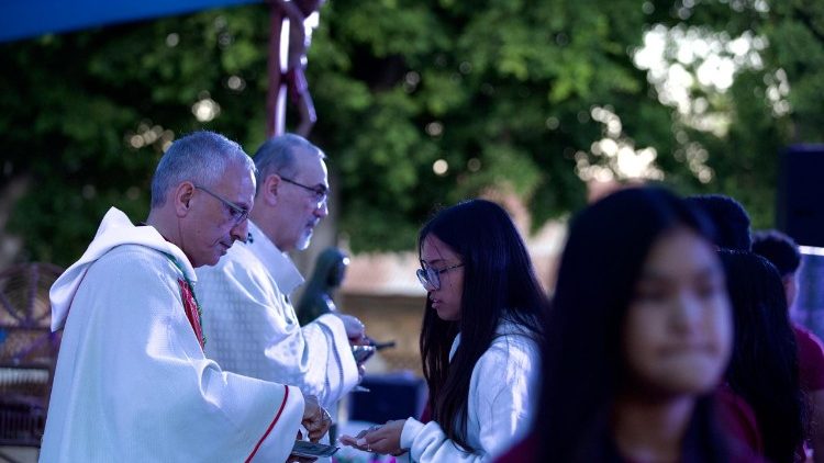 Cardinal Pierbattista Pizzaballa and Bishop Rafic Nahra administer Holy Communion to young people at the Youth Festival in Deir Rafat