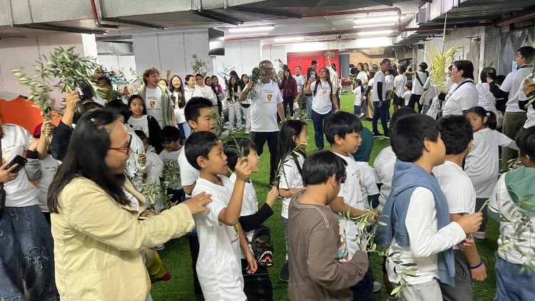 ילדים ומשפחות מקיימים את התהלוכה בתוך מקלט תת-קרקעי. (© האב פיוטר זלזקו, נציגות יעקב הצדיק)