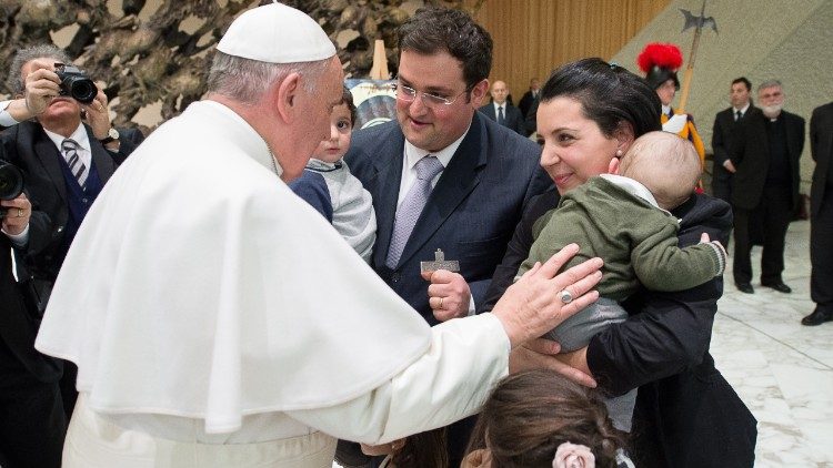 Papa Francesco con una famiglia in Aula Paolo VI