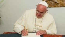 El Papa Francisco firma un documento, foto de archivo