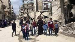 폐허가 된 알레포 시내에서 아이들과 함께 있는 피라스 루프티 신부님
