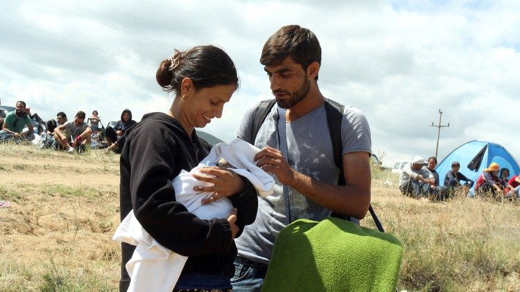 子を抱いたシリア難民の夫婦　セルビアとマケドニア国境の難民キャンプで