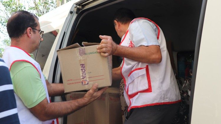Caritas members distribute aid during an emergency
