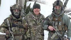 Ukrainos kariuomenės kapelionė A. Andriašina tarp dviejų karių (RISU)