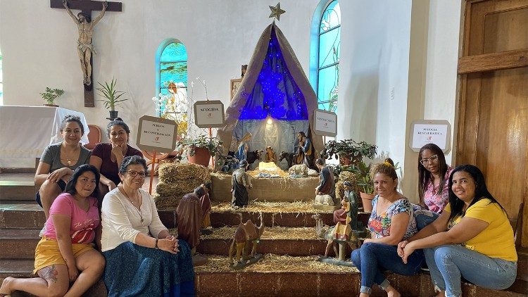 Sister Nelly and other women around a Nativity scene in the prison chapel