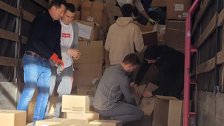 Voluntários ucranianos carregam o caminhão de ajuda que parte para a Ucrânia