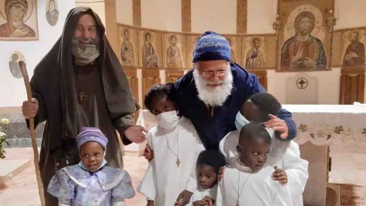 Don Pino Vitrano (a destra) con fratel Biagio e alcuni bambini nella chiesa "Casa di preghiera per tutti i popoli"