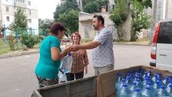 Don Taras Pavlius distribuisce acqua potabile