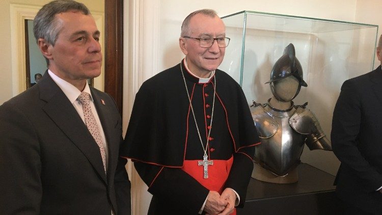 Bundesrat Cassis und Kardinal Parolin stehen neben einer Gardemontur - ein Geschenk der Schweizergarde