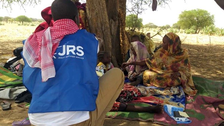 Ein Mitarbeiter des Jesuit Refugee Service mit Flüchtlingen aus dem Sudan