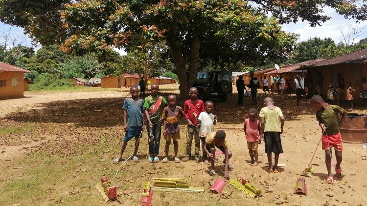 Crianças com brinquedos criados com materiais do local