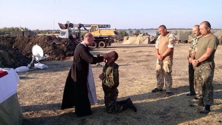 Bp Bohdan Manyszyn udziela Komunii św. żołnierzom