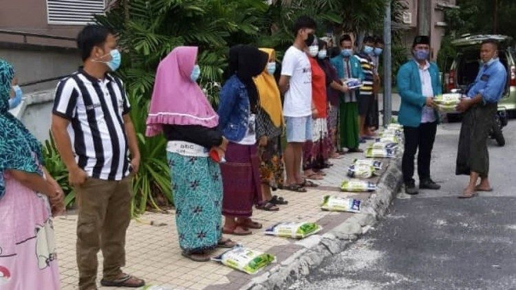 Distribuzione di aiuti alimentari durante la pandemia da parte di volontario della Nahdlatul Ulama