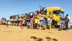 Sudão, uma coluna de refugiados amontoados em caminhões e meios de transporte.