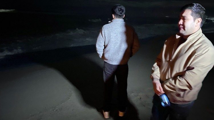 Due superstiti piangono di fronte al mare