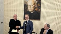 Der Jesuit Antoine Kerhuel (links) und Zachary Levine vom United States Holocaust Memorial Museum in Washington D.C am 27.2.2024 in Rom bei der Unterzeichnung des Abkommens. Applaus gab es auch von Joseph Donnelly (rechts), US-Botschafter beim Heiligen Stuhl
