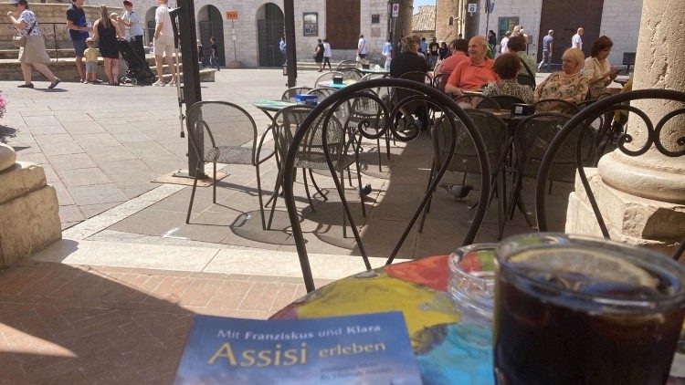Der spirituelle Assisi-Führer im Einsatz auf einem Tisch in einer Bar in Assisi - Foto: Michael Hermann 