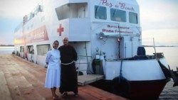 Suor Marcia Lopes Assis davanti alla “Barca Ospedale Papa Francesco” insieme a frate Afonso Lambert