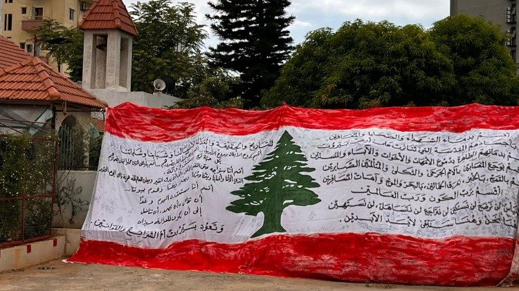 Libanonská vlajka se jmény obětí výbuchu v bejrútském přístavu, vystavená při vigilii v Bejrútu