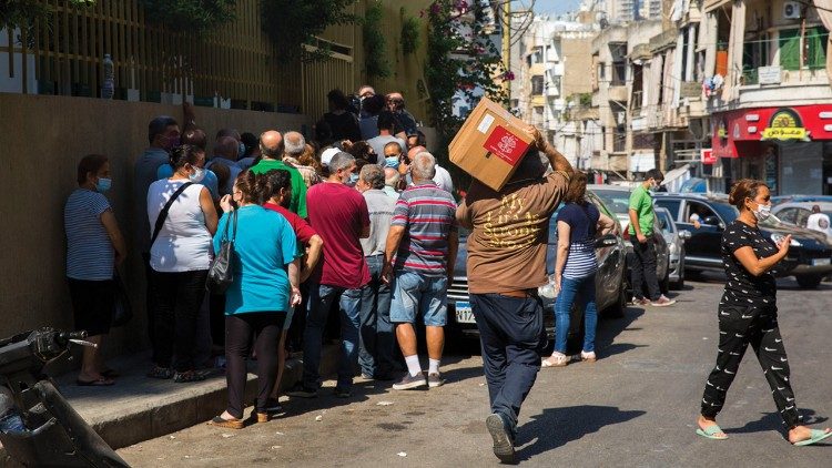 A man receives aid through the CNEWA-funded food box program at the Socio-Medical Intercommunity Dispensary in Nabaa, Lebanon. Photo: