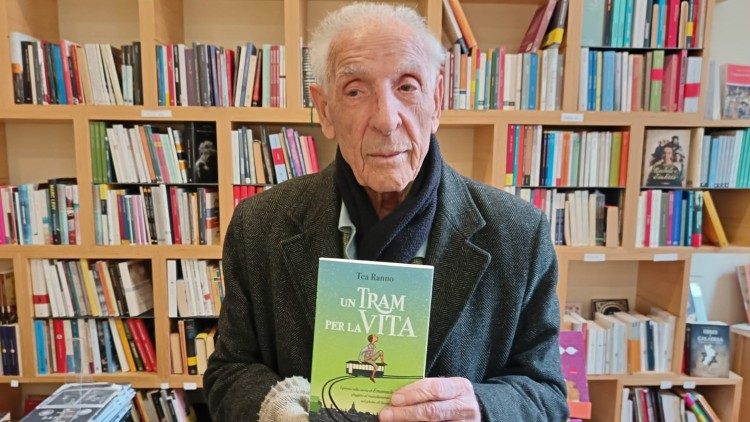 Emanuele di Porta mostra la copertina di un libro dedicato alla sua storia