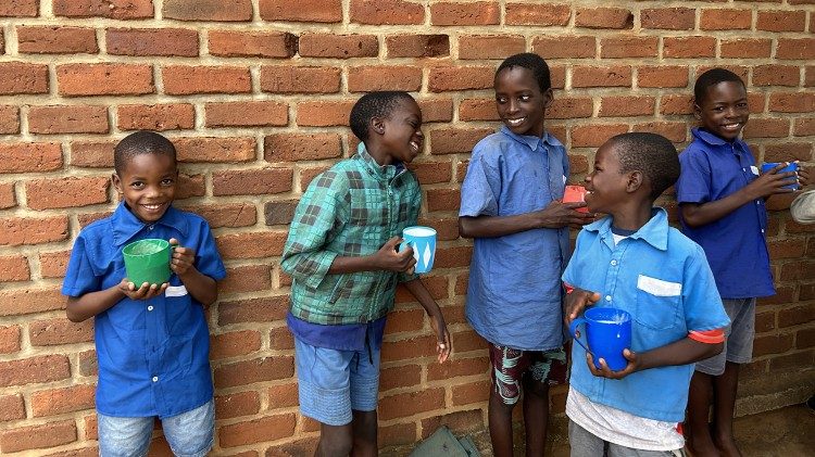 A group of boys laughing and enjoying their breakfast