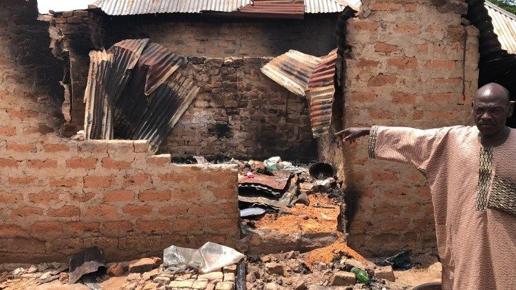 Un sopravvissuto indica una casa distrutta dalle fiamme