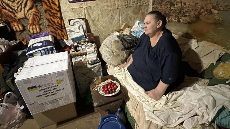 Una donna riceve il pacco di cibo, dono del Papa, nella sua casa