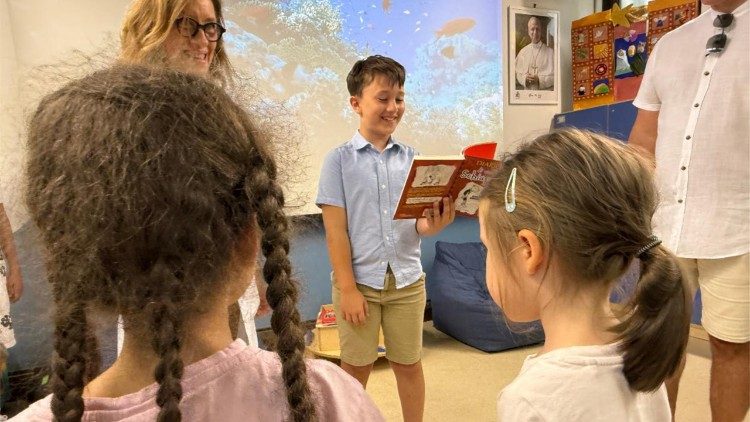 Sebastian mentre legge alcune pagine del libro ai bambini in cura presso l'Ospedale Pediatrico del Bambino Gesu