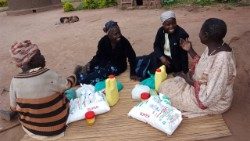 Sr. Linah Siabana, MSOLA (second from the right), visits the sick and elderly to provide essential food supplements