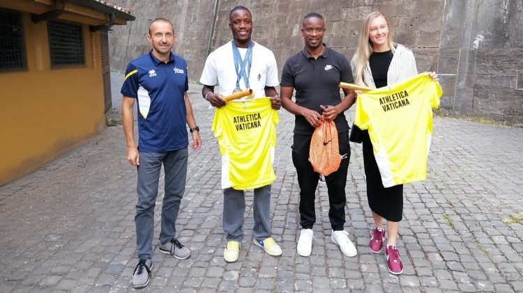 Olympic champion Letsile Tebogo (center), holding an Athletica Vaticana t-shirt