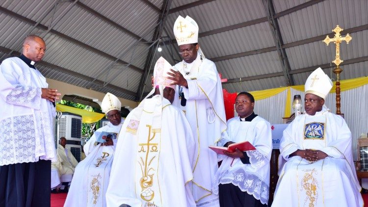 Kardinali Protase Rugambwa, akimpatia Askofu msaidizi vitendea kazi