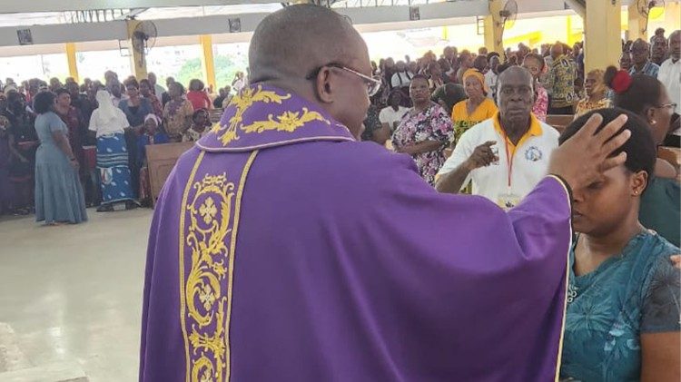 Le père Hyppolite Agnigori, imposant la Cendres à une fidèle en l'église Saint Jean Paul II de Cocody - Angré dans l’archidiocèse d’Abidjan - Côte d'Ivoire. 