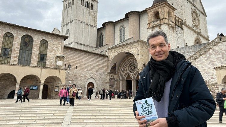 Autor Christian Busemann mit seinem Buch: „Easy nach Assisi - Pilgern für Einsteiger" vor der Unterkirche der Basilika San Francesco in Assisi, 16.3.2025 